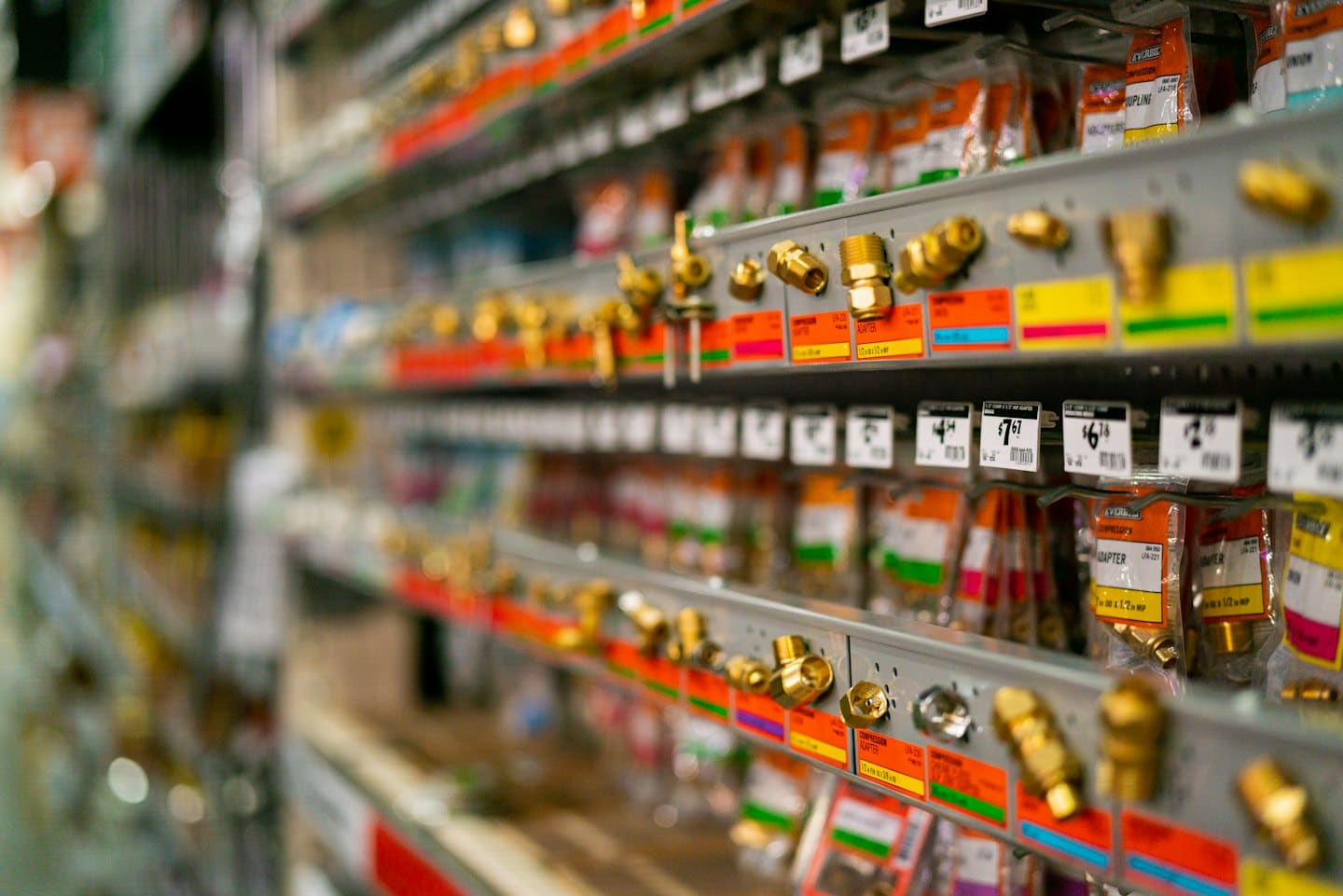 Rows of brass plumbing fittings and hardware on store shelves.